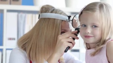 KBB doktoru küçük kızın kulağını muayene ediyor. Çocuk konseptinde işitme testi