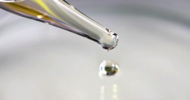 Cam pipetten altın rengi damlayan şeffaf bir sıvı. Petrol laboratuarı araştırma konsepti