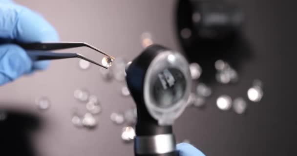 手袋をはめた宝石商は宝石でピンセットを保持し 虫眼鏡を通して検査する ダイヤモンドコンセプトの信頼性を決定する — ストック動画
