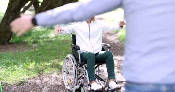 남자가 휠체어를 여성에게 달려가 그녀를 껴안는다 장애가 사람들 — 비디오