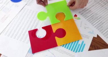 İş ekibi masaüstünde çok renkli plastik yapboz parçaları topluyor. Takım dayanışması ve beyin fırtınası takım çalışması ve fikir problemi çözme kavramı