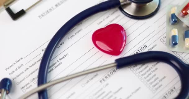 立体镜和红色玩具心脏躺在医疗文件上特写4K片慢镜头 心血管系统疾病的诊断与治疗 — 图库视频影像
