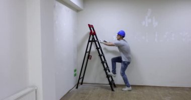 Mutlu erkek tamirci merdivene tırmanıyor ve ellerini kaldırıyor. Profesyonel kalite iş bitirme konsepti