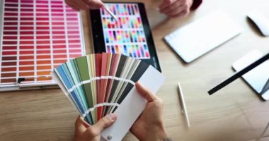 Designer and client selecting color from palette and digital tablet closeup 4k movie slow motion. Interior design concept