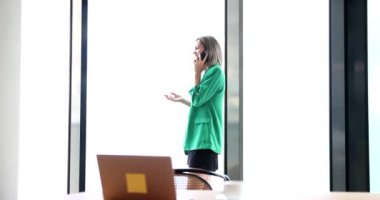 Businesswoman talking on mobile phone in office 4k movie slow motion. Break at work concept