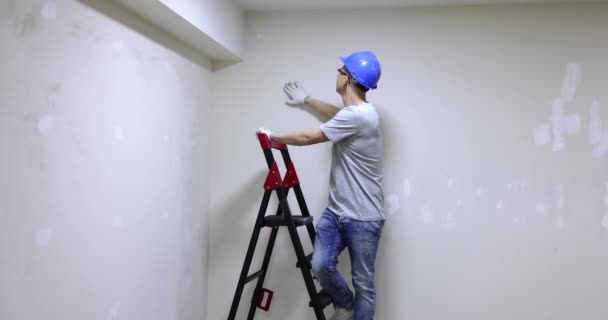 男工在头盔检查质量应用石膏墙壁和显示还好的姿态4K电影慢动作 公寓概念的高质量维修和装修 — 图库视频影像