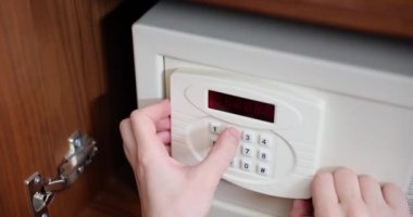 Male hand typing password on door of metal safe on door in hotel closeup 4k movie slow motion. Storage of valuables concept