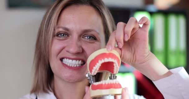 歯科医は口を開けて 人工プラスチック顎モデル4K映画スローモーション 歯科医療の概念 — ストック動画