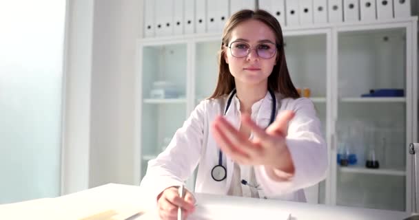 一位坐在桌旁的年轻妇女 一位医生 伸出了一只手 一个特写镜头 医疗咨询 — 图库视频影像