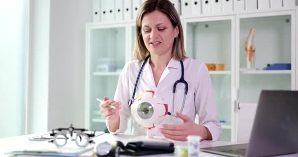 女性は医者で解剖学的モーダル目 クローズアップを示しています 眼科医の訓練医学教育 — ストック動画