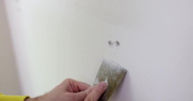 Eldeki duvarları yıkmak için, yakın plan bir spatula. Messual araç, ev onarımı, yavaş çekim