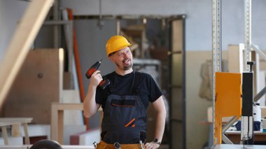 Aptal çalışan elektrikli matkap portre kullanarak. El ile iş DIY ilham geliştirme tamir dükkanı sarı kask sanayi başlangıç fikir endüstriyel eğitim meslek kariyer kavramı