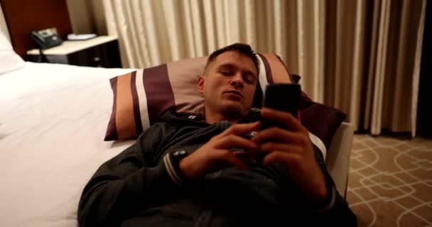 Homem Deitado Cama Com Telefone Celular Nas Mãos Falando Vídeo — Vídeo de Stock