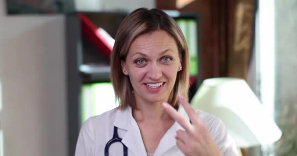 Dokter Wanita Tersenyum Menunjukkan Gerakan Yang Mengikuti Pasien Film Gerak — Stok Video