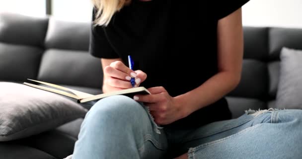 Γυναίκα Κάθεται Στον Καναπέ Στο Σπίτι Και Γράφει Σημειώσεις Στο — Αρχείο Βίντεο