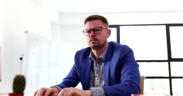 Wściekły Menadżer Okularach Pracujący Przy Komputerze Machający Pięścią Przed Kamerą — Wideo stockowe