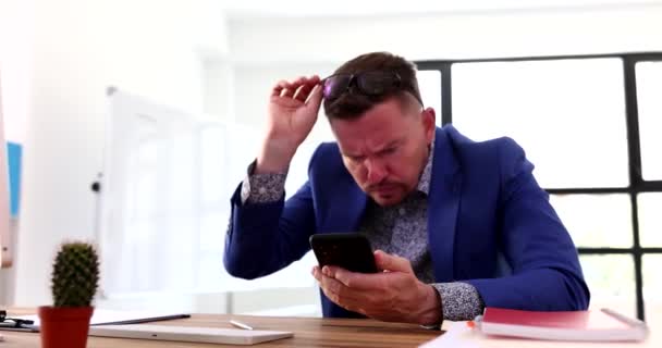 ビジネスマンは携帯電話でニュースやメッセージを待っていると彼の手を振っ無関心で4K映画 失敗とビジネスの問題の概念 — ストック動画