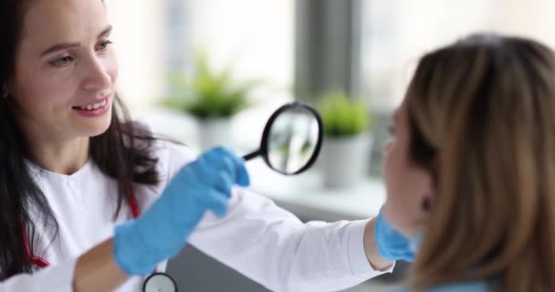Dokter Memeriksa Kulit Wajah Wanita Menggunakan Kaca Pembesar Film Gerak — Stok Video