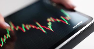 Kadın, dijital tablet üzerindeki kripto para birimlerinin grafiğini inceliyor. Yakın çekim 4K film ağır çekim. Elektronik para kavramı