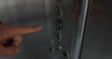 Asansörde insan eli bir numaraya basar. Asansör konsepti kullanımı