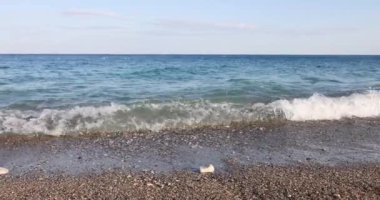 Güneşli bir günde sahilin dalgalı ve taştan sahili manzarası. - Evet. Rocky plajı konsepti