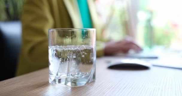 Glas Wasser Sprudelt Und Hintergrund Läuft Eine Frau Trinkkuren Bei — Stockvideo