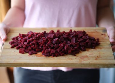 Kesme tahtasında taze ev yapımı dilimlenmiş pancar. Vegan yemeği hazırlamak için doğal malzemeler..