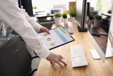 Analizci işyerinde grafiklerle dolu bir pano tutuyor. İstatistik iş göstergeleri konsepti hazırlanıyor