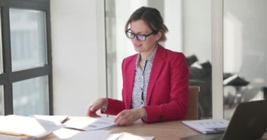 Gülümseyen iş kadını ofiste belgelerle çalışıyor. Belge ile başarılı bir yönetici