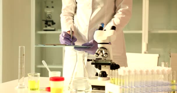 Wetenschapper Bioloog Schrijft Notities Met Behulp Van Microscoop Het Laboratorium — Stockvideo