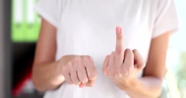 Closeup of woman showing middle finger making fuck you gesture. Concept of bad and offensive expressions
