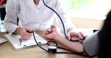 Doktor kardiyolog klinikteki hastaya kan basıncını ölçüyor. Gerekli hipertansiyon ve arteryel hipertansiyon
