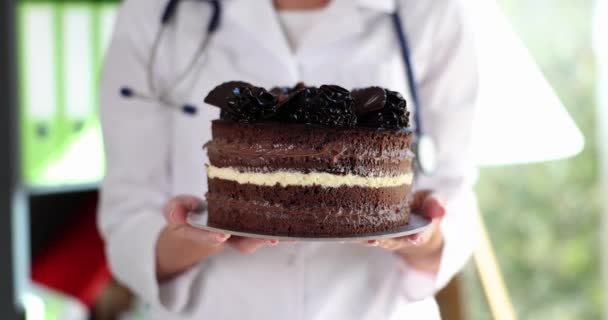 Hände Eines Ernährungsmediziners Der Einen Kalorienreichen Schokoladenkuchen Der Hand Hält — Stockvideo
