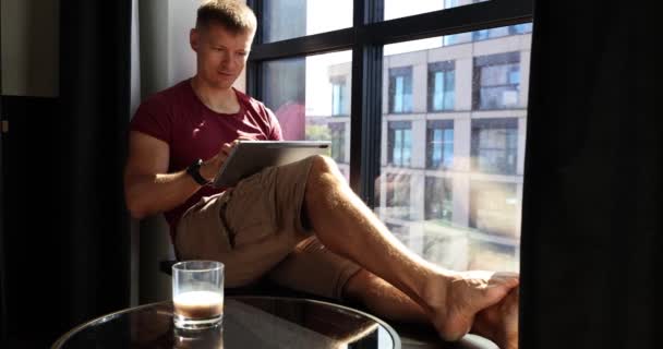Concentrated Man Freelancer Working Laptop Sits Windowsill Table Drink Online — Stock Video