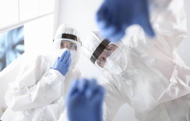 Koruyucu antiveba elbiseli doktorlar hastaya yardım ediyor. Covid-19 konsepti olan hastalar için acil bakım