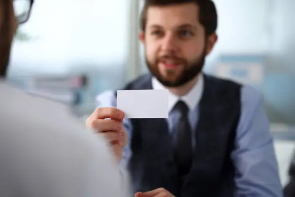 Male arm in suit give blank calling card to visitor closeup. White collar colleagues company name exchange job interview sale clerk id executive or ceo finance support formal identity etiquette