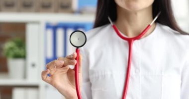 Kırmızı steteskop tutan kadın doktor. Terapist hizmetleri kavramı