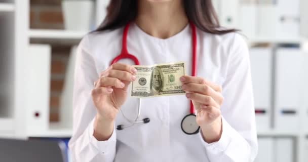 女医生拿着100美元的钞票 有偿医疗服务概念 — 图库视频影像