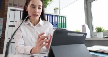 Ofisteki bir kadın video bağlantısıyla konuşuyor, yakın çekim, yavaş çekim. Çevrimiçi sunum, müzakereler