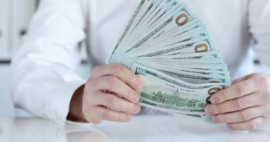 İş adamı bir deste dolar gösteriyor, yakın çekim, yavaş çekim. İş yatırımı, kredi, tutucu