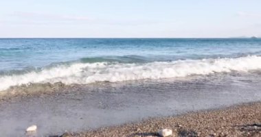 Deniz kıyısında güzel mavi sörf, çakıl taşı plajı, sinema. Okyanus kıyısı manzarası, yavaş çekim