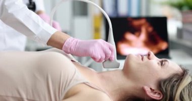 Doktor bir kadın için tiroit bezinin ultrasonunu yapıyor, yakın plan. Hipotiroidizm teşhisi, tıbbi ekipmanlar