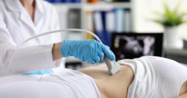 Doktor karın boşluğunun ultrasonunu yapar, yakın plan. Pelvik organların teşhisi, tıbbi ekipmanlar.