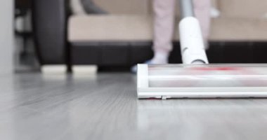 Evde bir kadın plaminatı elektrikli süpürgeyle temizliyor, yakın plan. Ev aletleri, sığ odak