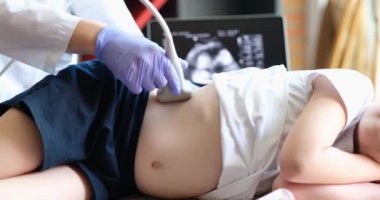Doktor karaciğerin ultrasonunu çocuğa yapar, yakın plan. Klinik araştırma, hastalık teşhisi, pediatri.