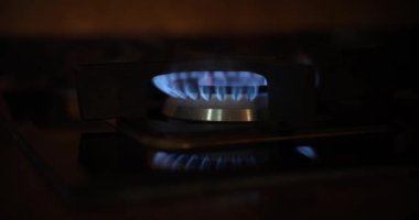 Gaz ocağının mavi alevleri, sobanın üzerinde, yakın plan. Dünyadaki gaz krizini hesaba katın. Yakıt tedarik sorunu