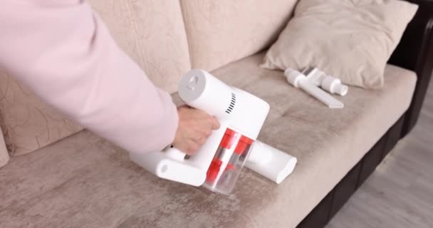 一个女人用吸尘器把米色的沙发吸空 用吸尘器洗净 家用电器 公寓清洁 — 图库视频影像