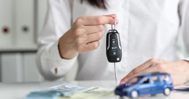 一个女人拿着车钥匙 钱在桌子上 慢动作 购买车辆 — 图库视频影像