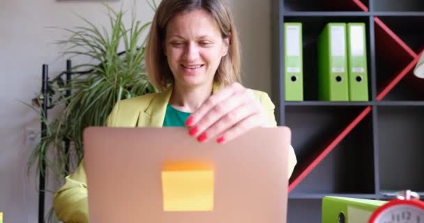緑のスーツの幸せな女性は オフィスで クローズアップノートパソコンを開きます 作業日の開始 ワークスペースのインテリア — ストック動画