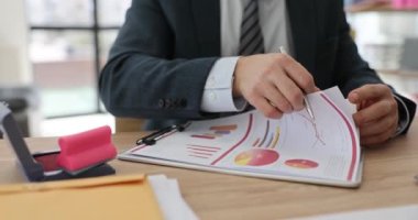 Bir iş adamı dosyadaki raporları yakından izliyor. Şirketin belgelerinin koordinasyonu